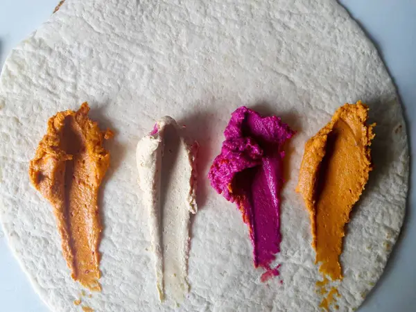 Düz ekmekte sunulan renkli ve canlı yiyecekler herhangi bir sosyal toplantıda görsel olarak çekici bir aperatif oluşturur.