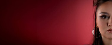 Bir modelin çarpıcı ve detaylı bir yakın çekimi gururla parıltılı ve canlı renklerle geliştirilmiş cesur bir görünüm sergiliyor.