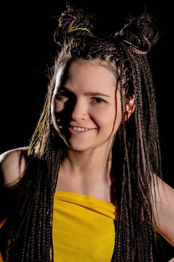 Çarpıcı bir kıyafeti ve göz alıcı saç tasarımı olan etkileyici bir genç kadının büyüleyici portresi.