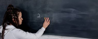 Hevesli bir eğitimci, etkili bir eğitimin önemini vurgulayan bir yazı tahtasına özenle yazar.