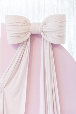 Güzel, yumuşak ve zarif bir fiyonk. Lüks kumaşa bağlanmış. İlham verici bir gelinlik ya da resmi giysi için ideal.