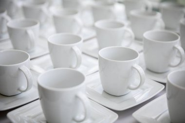 Temiz düzenlenmiş, yemek servisi ya da etkinlik ayarları için ideal el değmemiş beyaz bardakların güzel bir koleksiyonu.