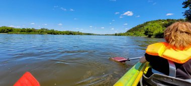 Şu anda yemyeşil yemyeşil bir nehrin üzerinde huzurlu ve huzurlu bir kano yolculuğunun tadını çıkarıyorum.