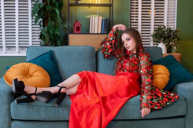 Moda mankeni lüks bir koltukta zarif bir şekilde uzanır, zahmetsizce modern ve şık bir zarafet sergiler.