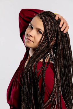 Gerçekten büyüleyici ve büyüleyici genç bir kadın kendinden emin bir şekilde uzun örgülü saçlarını sergiliyor.