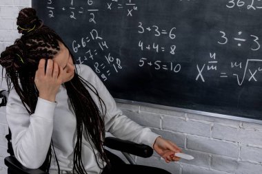 Sınıfta, karmaşık matematik denklemleriyle uğraşan çalışkan bir öğrenci, anlamak için çok çalışıyor.