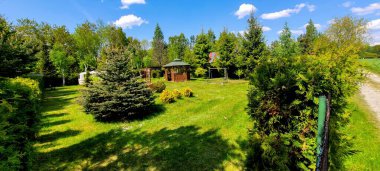 Güzel bir bahçe, yemyeşil, zarif bir çardak, ve mavi bir gökyüzü, rahatlamak ve dinlenmek için mükemmel.