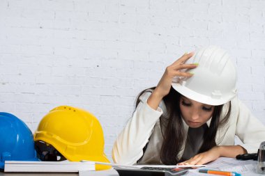 Bir mühendis, inşaat süreci boyunca güvenlik ve etkili planlama üzerine odaklanarak proje planlarını gözden geçirir