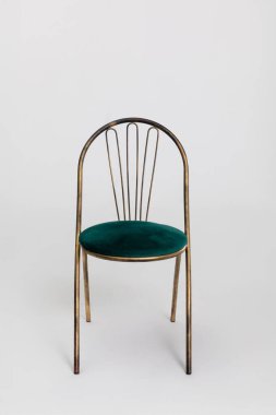 Metalik çerçeveli şık bir sandalye ve rahat yeşil kadife bir koltuk, modern iç mekanlar için mükemmel..