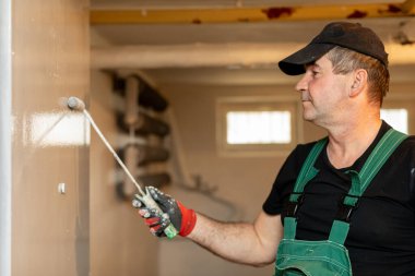 Becerikli bir işçi, fevkalade bir ev yenileme ve tasarım uzmanlığı sergileyen bir iç duvarı ustalıkla boyar.