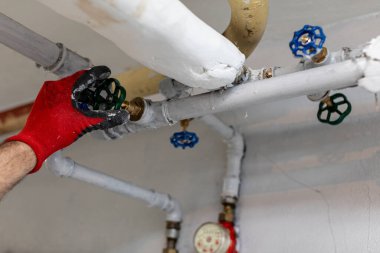 Yetenekli bir işçi, tesisat sistemindeki vanaları titizlikle ayarlar ve gerekli bakım becerilerini gösterir.