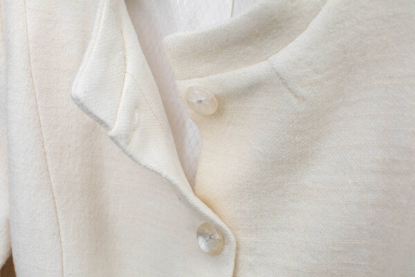 Крупный план модного внебелого свитера, подчеркивающего его уникальные кнопки и сложную текстуру