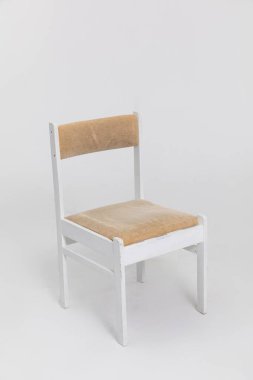 Modern ve şık iç mekanlar için ideal, güzel hazırlanmış doğal koltuğu olan şık ve minimalist beyaz bir sandalye.