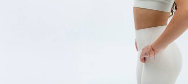 Şık bir model, kendine güvenen bir şekilde şık bir kıyafet ve yüksek bel pantolon sergiliyor.