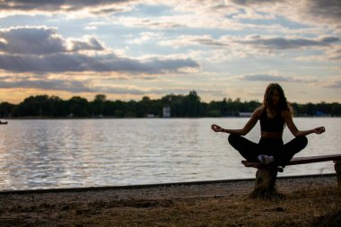 Gün batımında göl kenarında sakin bir meditasyon anı iç huzuru ve farkındalığı teşvik eder.
