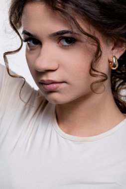 Büyüleyici bir portre kıvırcık saçlı genç bir kadının ince ve merak uyandıran bir ifadeyle birlikte