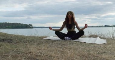 Huzurlu suyun yanında huzurlu, huzurlu bir meditasyon anı, derin farkındalık ve sükuneti vurguluyor.