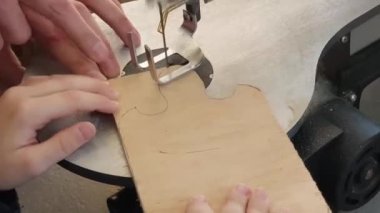 Çocuk makinede ekmek dilimlemek için tahta kesiyor. İşçi eğitimi dersi. Öğretmen öğrencinin tahtayı silmesine yardım eder. Anneme bir hediye. Hollywood ürünleri. DIY okul projesi. Yüksek kaliteli HD görüntüler.