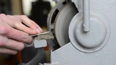 Kapalı adamlar atölyede tırnağı keskinleştirir. Çilingir bankta çalışıyor. Emery. Metal işçiliği. İşçi eğitimi dersi. Kıvılcımlar saçar. Yüksek kalite Tam HD görüntü