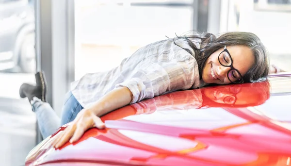 Podekscytowana Kobieta Przytula Swój Nowy Wymarzony Czerwony Samochód Salonie Samochodowym — Zdjęcie stockowe