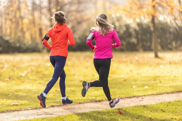 Dwie Młode Kobiety Fitness Biegające Jesiennym Parku — Zdjęcie stockowe
