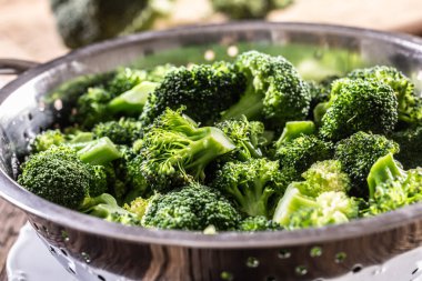 Steamed broccoli in a stainless steel steamer - Close up. Healthy vegetable concept.