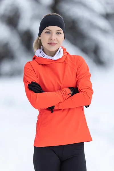 Portrait of a young runner in thermal clothing. Good looking female trainer in warm clothes during training in winter season.