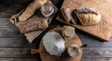 Bakery concept, flour bread and glasses with rye sourdough on the table. - Top of view.