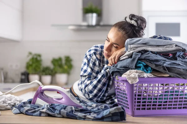 stock image Wife fell asleep on a pile of clothes in the basket keeping the iron on next to her.