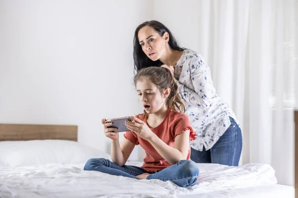 Annesi Çocuğunun Izlediği Internet Içeriğini Kontrol Etmeye Çalışırken Kızı Telefonda — Stok fotoğraf
