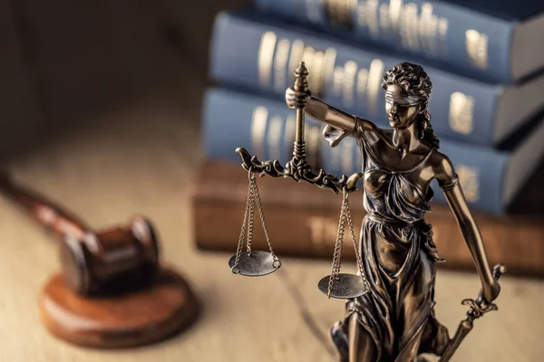 stock image Statute of Justice and law books in the background.