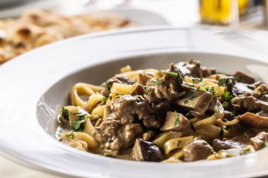 Bir tabak dolusu yaban mantarlı ve sosisli tagliatelle..