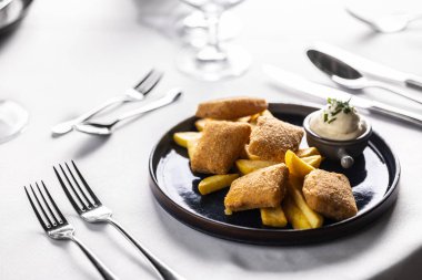 Patates kızartmasıyla kızartılmış ve mayonezle servis edilmiş peynir parçaları. Çocuk menüsü tavuk nugget ve patates dilimli lüks bir restoranda..