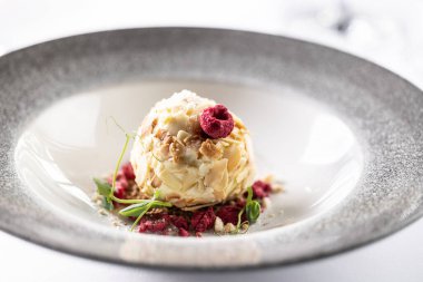 Kırmızı meyveli ve yeşil süslemeli top şeklinde beyaz çikolata kreması..