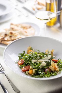 Parmesanlı roket salatası, fitalis ve vişneli domates yanında düz ekmek..