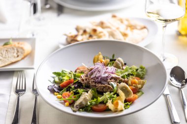 Karışık yeşillikler, mısır, kiraz domatesleri, avokado salatası, üstüne ton balığı ve çiğ soğan..