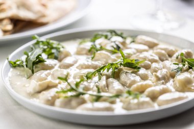 Gnocchi ai quattro formaggi, üzerinde dört çeşit peynir ve roka bulunan İtalyan hamur makarnası..