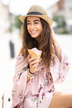 Sıcak bir yaz gününde elinde dondurma tutan güzel bir bayanın portresi..