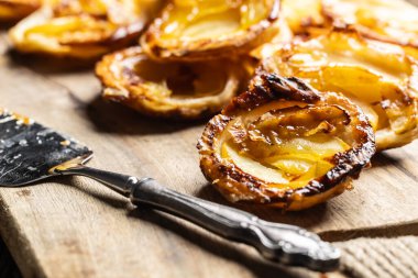 Kesme tahtasındaki puf böreğinden ve dilimlenmiş elmadan yapılmış mini turtalar. Fransız elmalı kekleri..