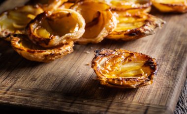 Kesme tahtasındaki puf böreğinden ve dilimlenmiş elmadan yapılmış mini turtalar. Fransız elmalı kekleri..