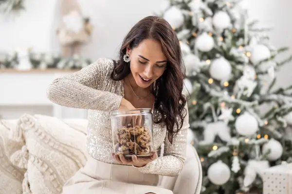 Woman is exciting to take a cookie out of the jar during Christmas.