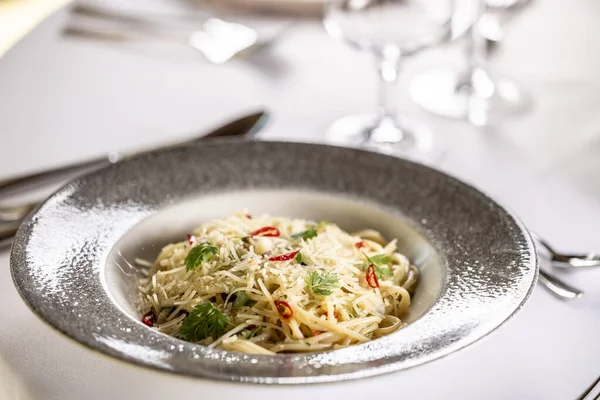 İtalyan spagettisi Algio e Olio sarımsaklı parmesan ve biberli restoran şenlik masasında.