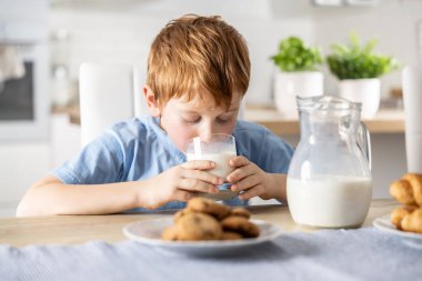 Tatlı çocuk kahvaltıda taze süt içer..