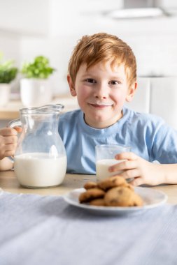 Süt içen ve bıyığı olan küçük bir çocuğun portresi..