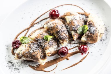 Doğu Avrupa geleneksel yemek köfteleri - pierogi, varenyky, pirohy çilekle dolu ve çikolatayla kaplı. Beyazda izole edilmiş.