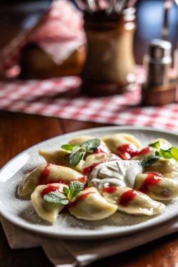 Doğu Avrupa geleneksel yemek köfteleri - pierogi, varenyky, pirohy çilek dolu ve reçelli.