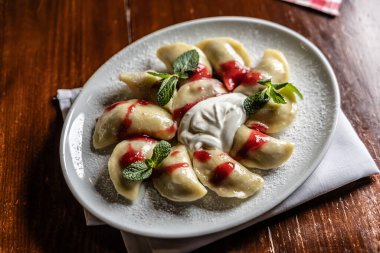 Doğu Avrupa geleneksel yemek köfteleri - pierogi, varenyky, pirohy çilek dolu ve reçelli.