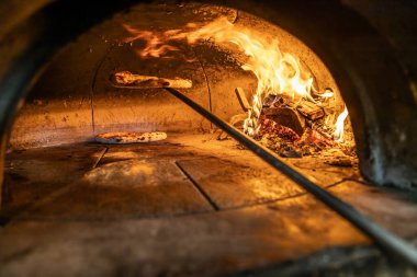 Yanan odun ve kürekle pizza pişirmek için geleneksel fırın. Napoli pizzası, tuğla fırınında kürekle yapılır..