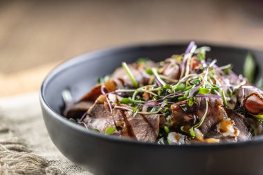 Biftek salatası, şifalı otlar ve balzamik sosla restoran masasında kase şeklinde..