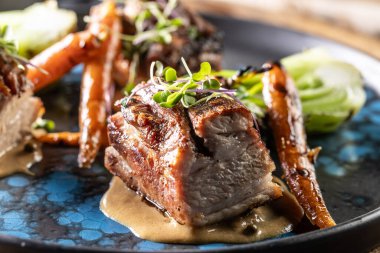 Barda ya da restoranda bir tabakta ızgara sebzeli üç parça pişmiş göbek..